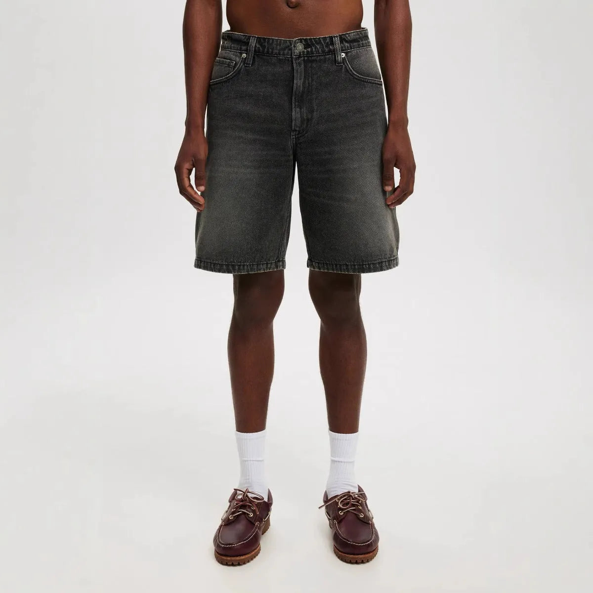 Men's loose straight leg jeans in light blue denim on a plain background