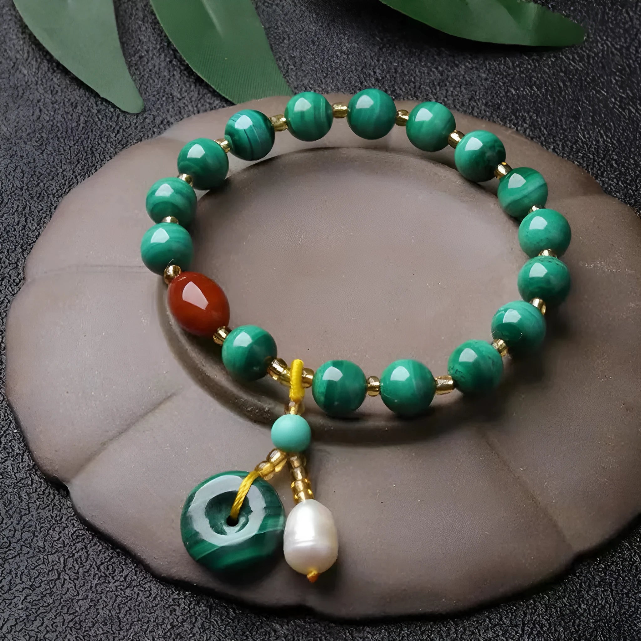 Natural malachite and red agate barrel bead bracelet with silver fittings on a woven elastic cord.