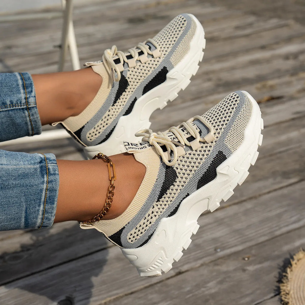 Women's Flyknit Mesh sneakers in a neutral colour showing lace-up design and rubber sole.