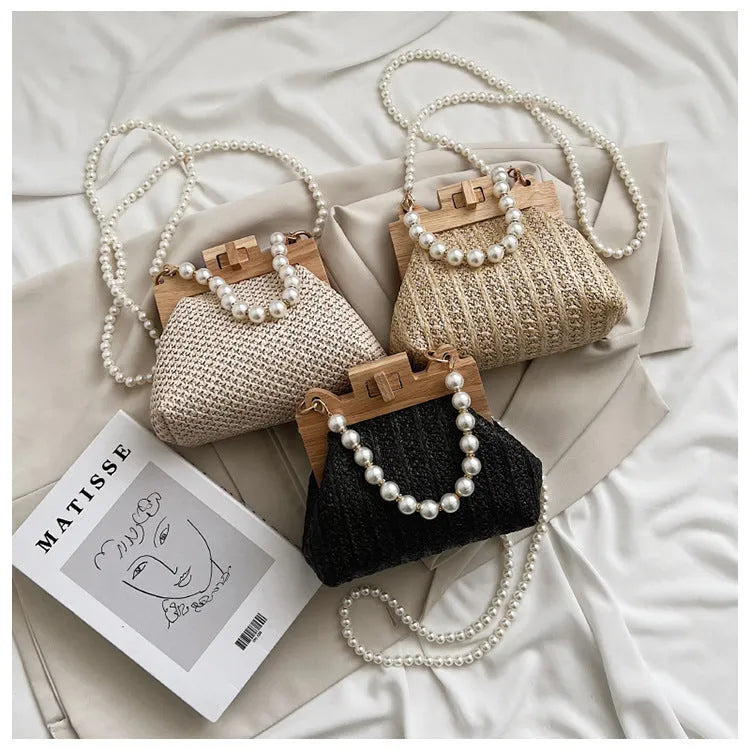 Beige woven straw women's shoulder bag with pearl chain detail, showing interior zipper pockets.