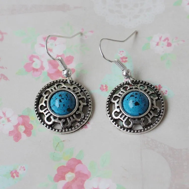 Handmade geometric flower disk earrings in Tibetan silver and turquoise with auspicious cloud patterns.