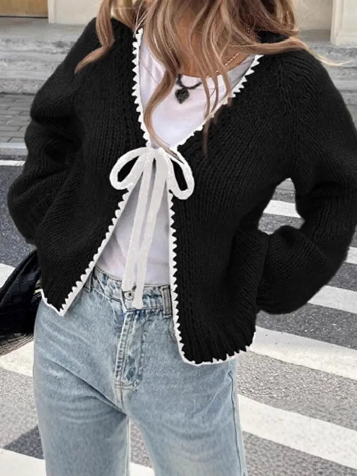 Gray lace-up cardigan sweater with long sleeves and crocheted flower decoration on the front.
