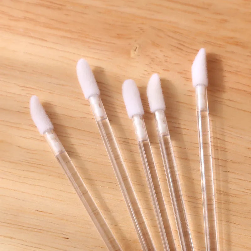 Pack of disposable lip brush wands with flocked brush tips and coloured handles.