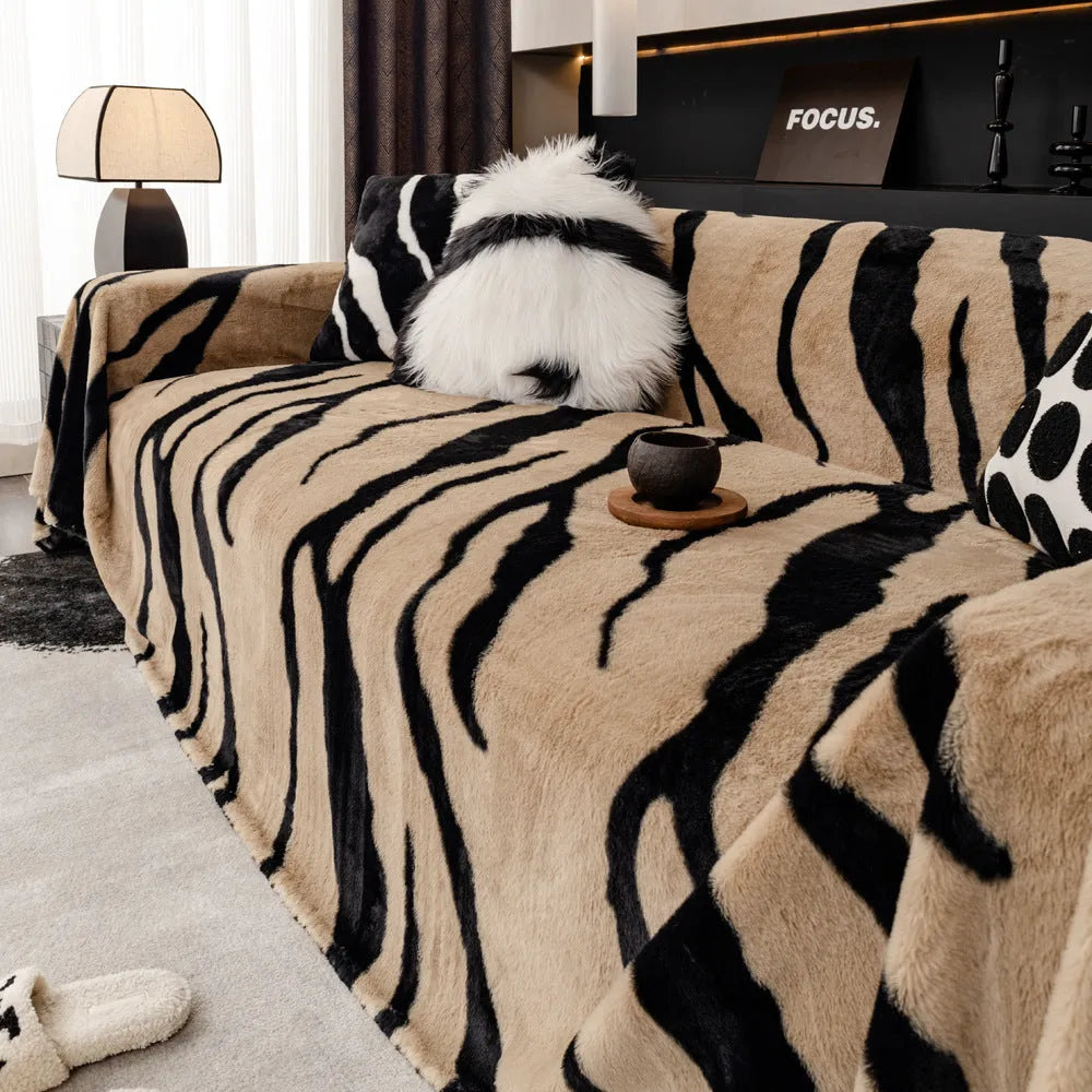 Zebra pattern flannel sofa slipcover in caramel colour, shown draped over a sofa with matching square pillow.