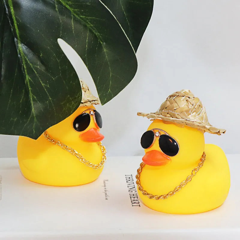 Straw hat yellow duck car dashboard ornament with removable sunglasses necklace on adhesive base.