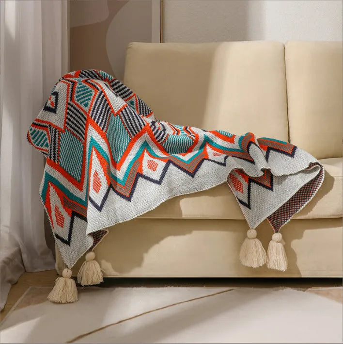 Acrylic sofa blanket with tassels in geometric pattern colour option on a sofa