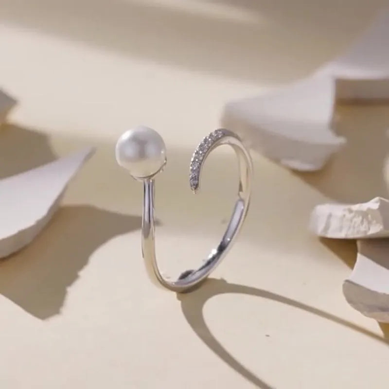 Adjustable sterling silver ring with natural shell pearls showing open loop design