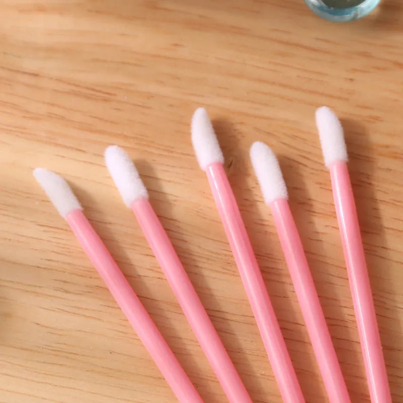 Pack of disposable lip brush wands with flocked brush tips and coloured handles.