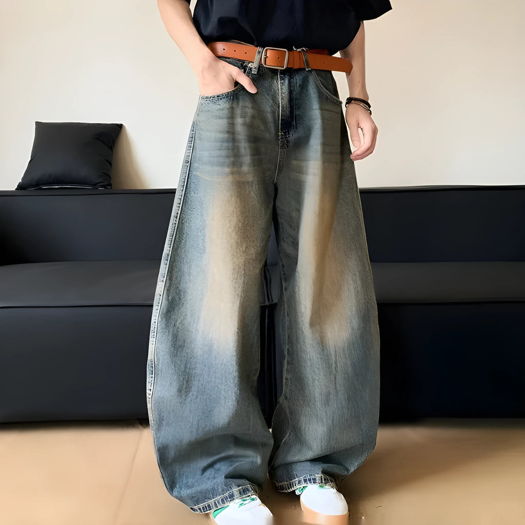 Man wearing retro blue distressed wide-leg denim trousers with a slimming fit.
