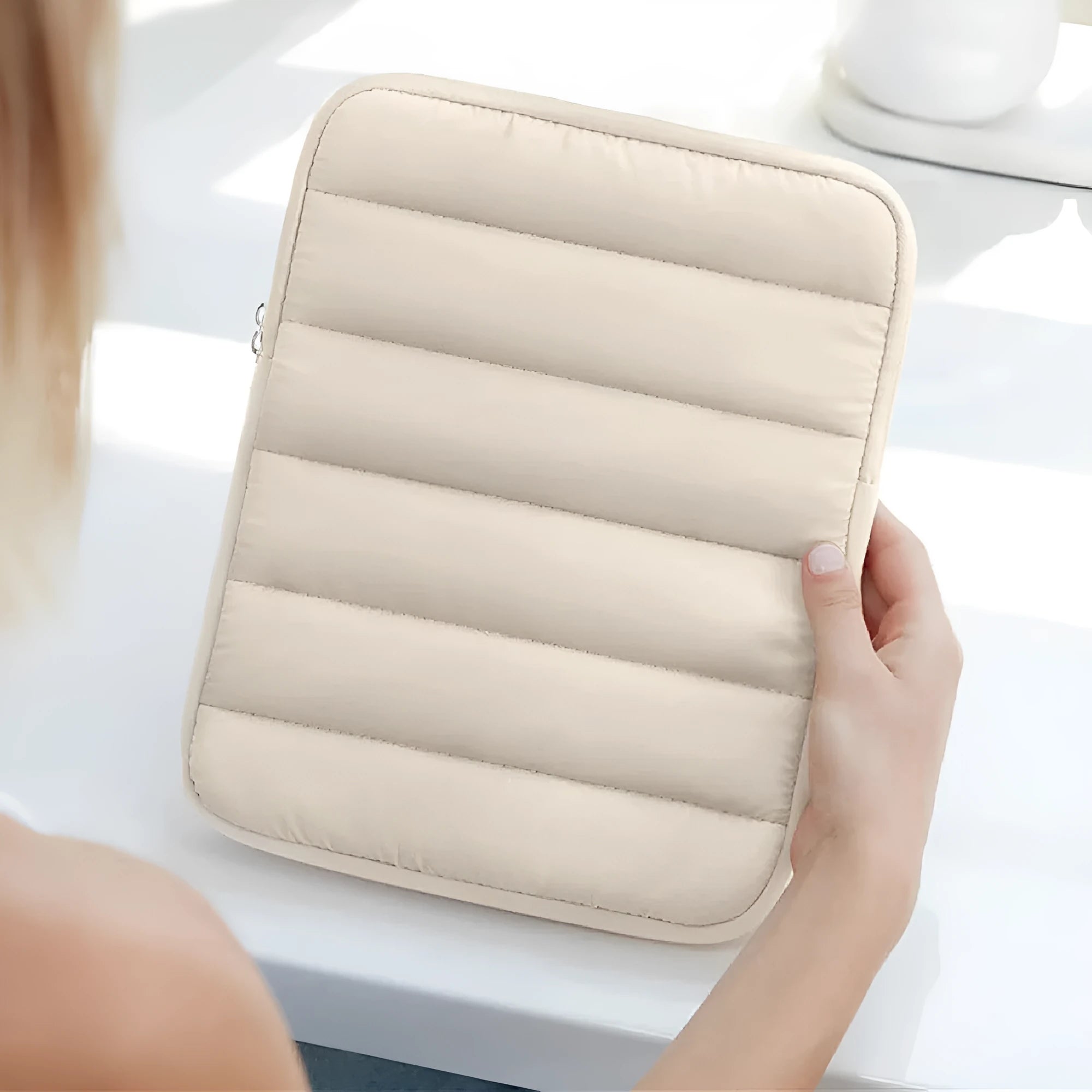 Black padded laptop sleeve with elastic sides for 9.7-11 inch devices, shown next to a storage bag.