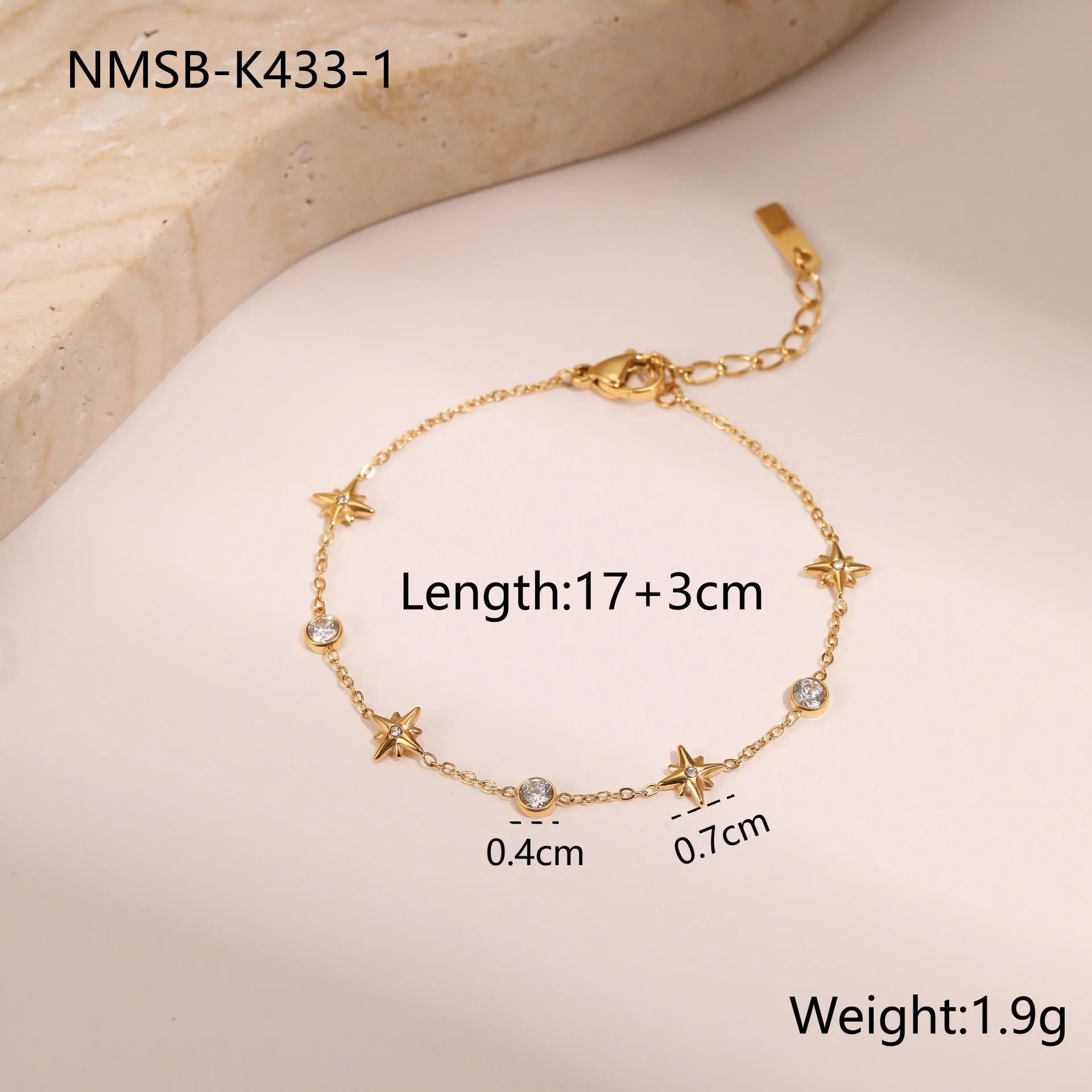 Gold plated stainless steel bracelet with a detailed zircon star pendant on a woman's wrist.