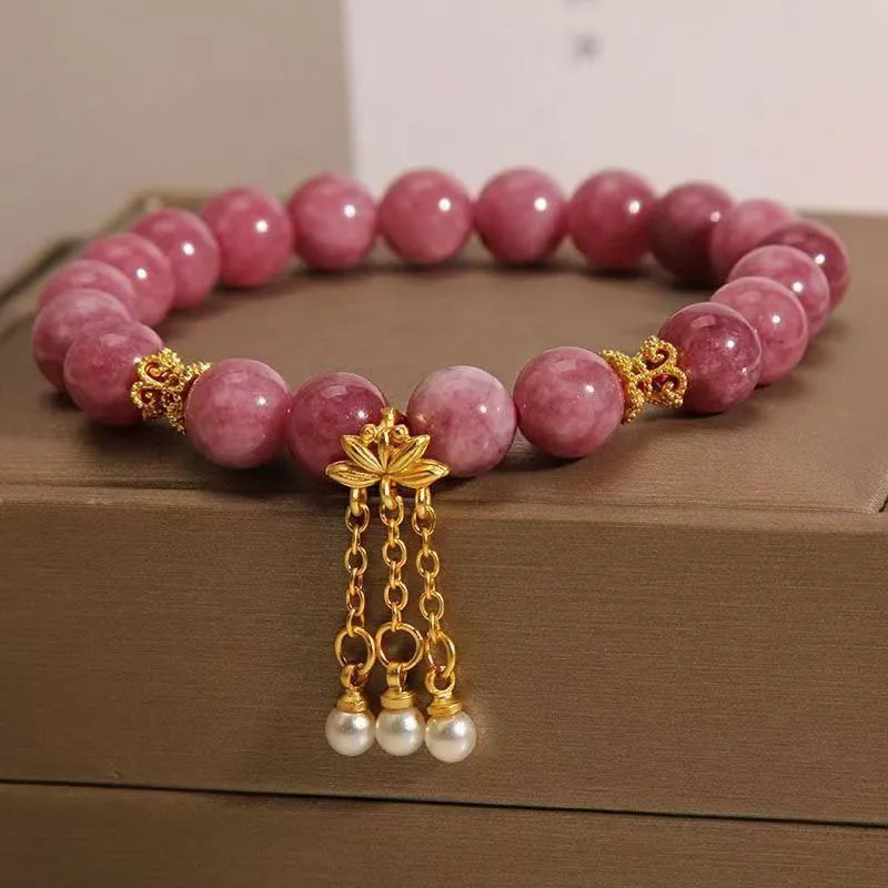 Pink and white natural stone bracelet with lotus flower pendant and tassel.