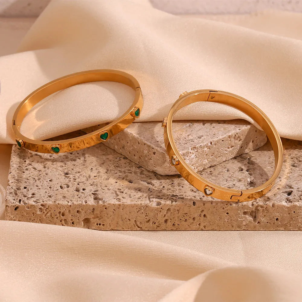 Golden stainless steel bracelet with a small micro-inlaid peach heart pendant.