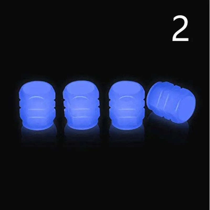 Pack of green and blue luminous rubber tyre valve caps on a car tyre valve.
