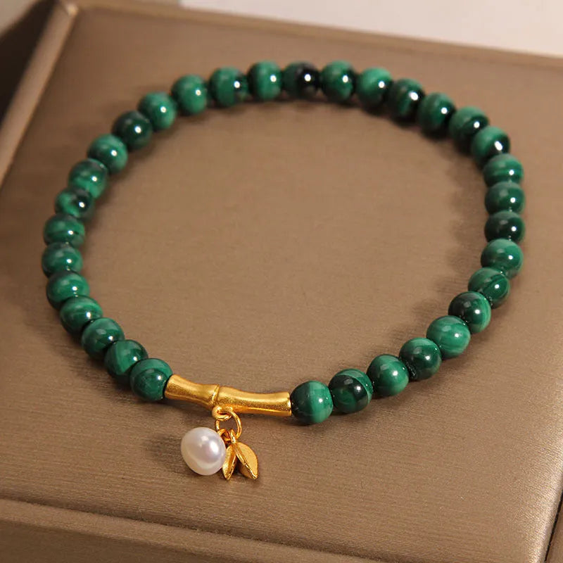 Close-up of a women's white crystal bracelet with a raised lucky bamboo design on the wrist.