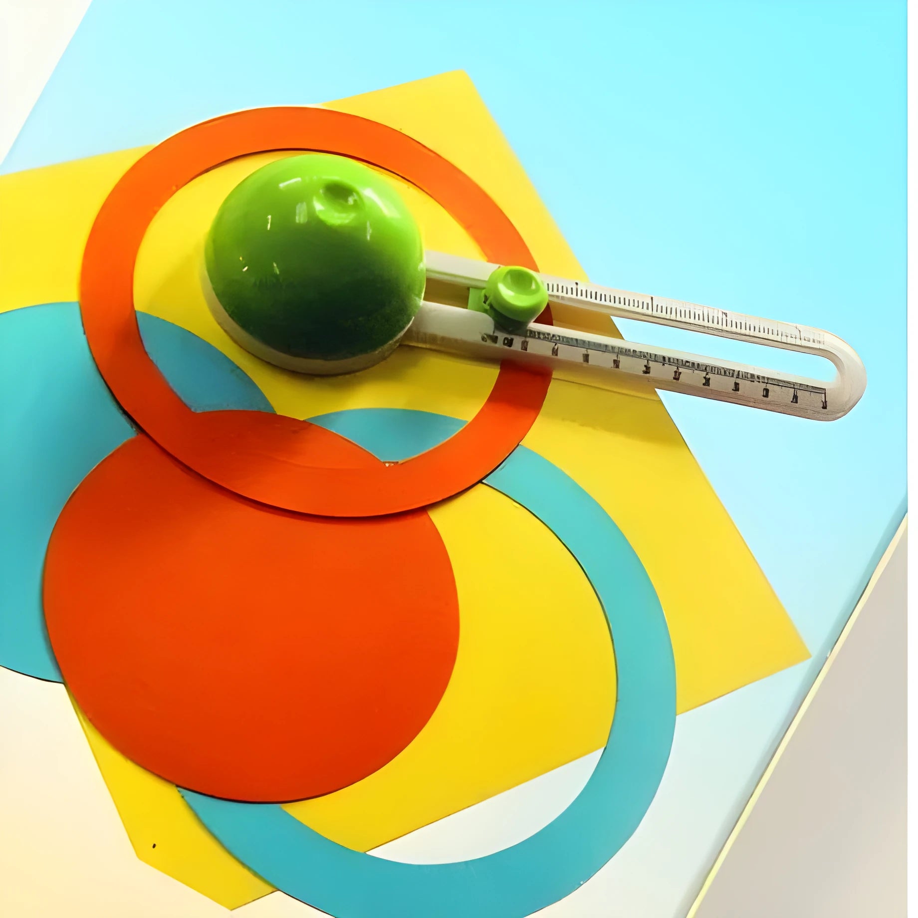 Green or orange plastic round paper cutter for A3 sheets on a colour box