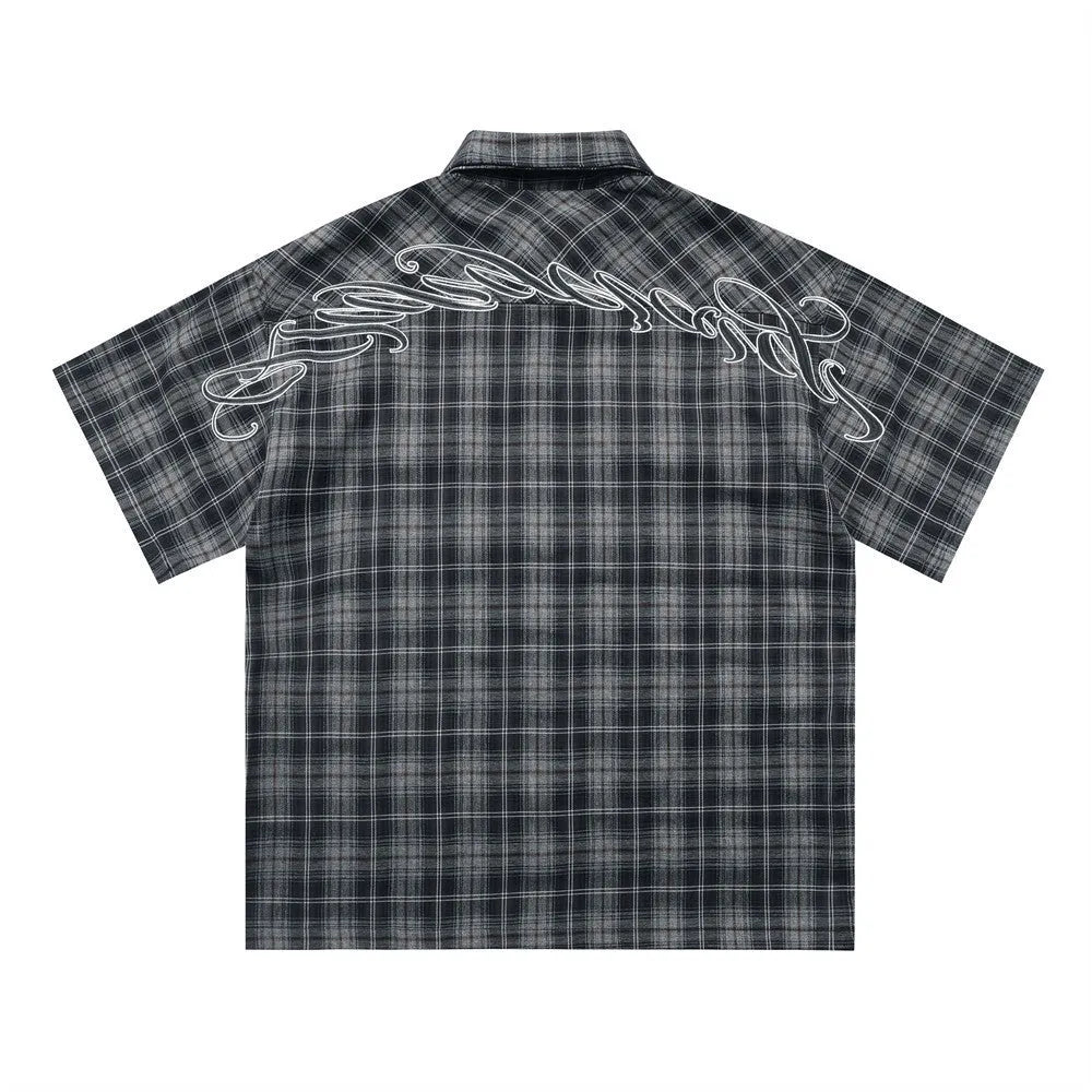 Men's black and brown plaid short sleeve shirt with embroidered letter design and lapel collar.