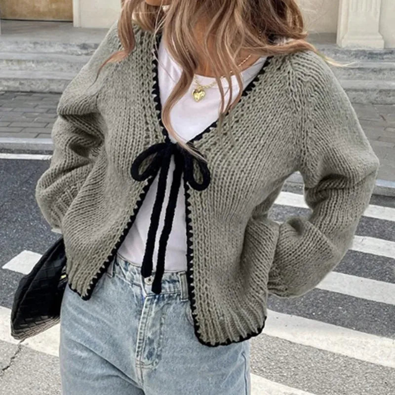 Gray lace-up cardigan sweater with long sleeves and crocheted flower decoration on the front.