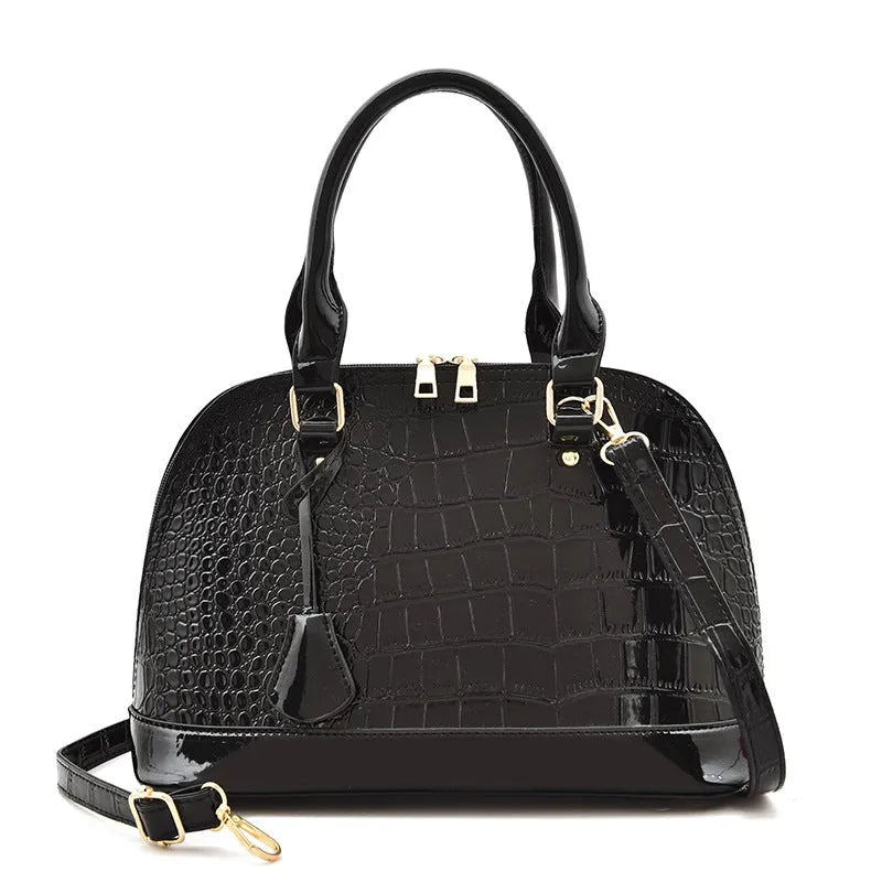 Shiny black PU crossbody bag with a structured shell shape and an adjustable strap.