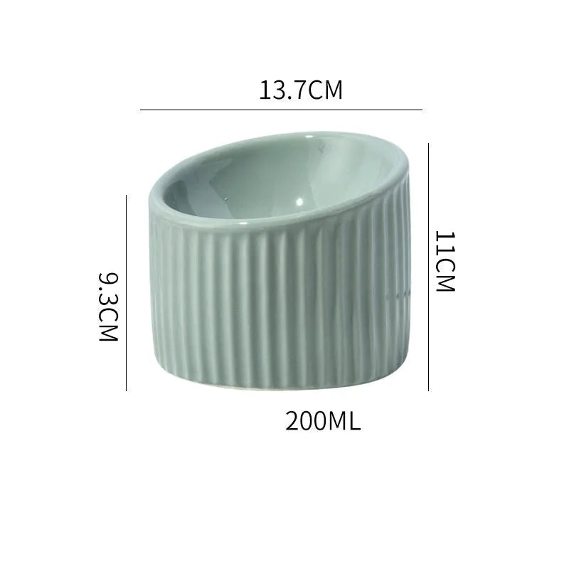 Dark green ceramic elevated cat bowl with tilted design on a wooden surface.