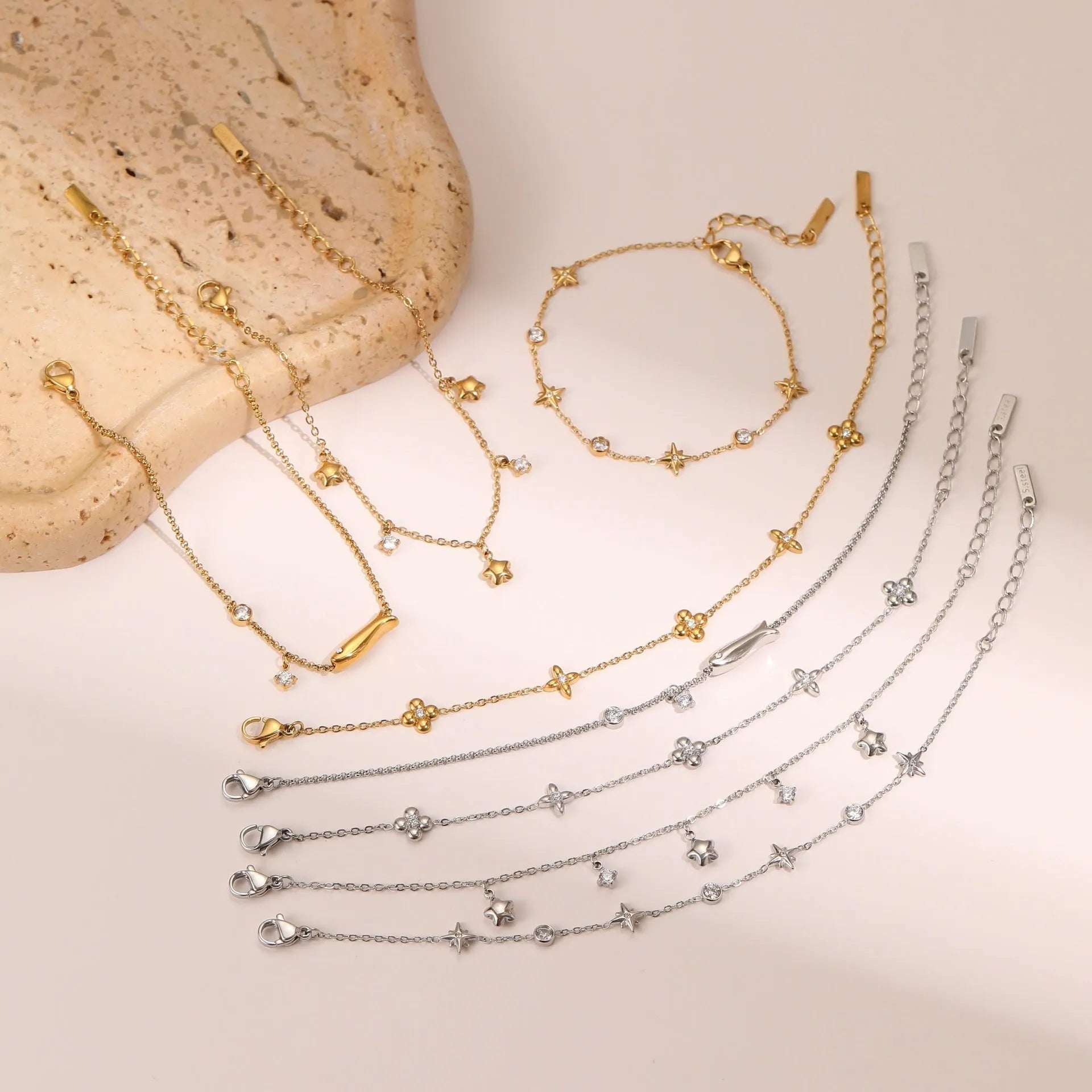 Gold plated stainless steel bracelet with a detailed zircon star pendant on a woman's wrist.
