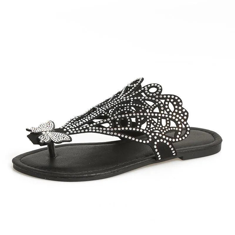 Women's black slip-on sandals with rhinestone decoration and flip-toe design.