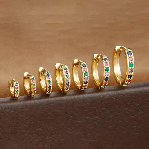 A pair of round gold-coloured stud earrings with a geometric perforated design and central zircon stone.