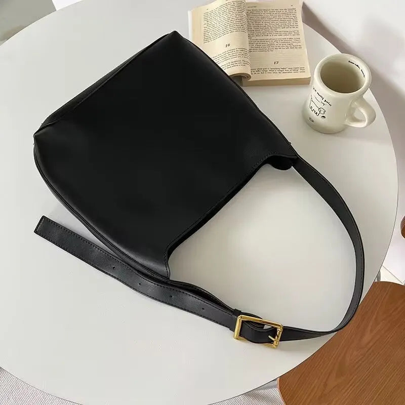 Women's soft PU leather shoulder bag with swing threads in black and brown colours showing ribbon and pocket detailing