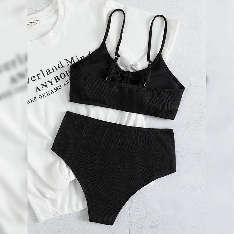 Black high-waisted bikini swimsuit for women with sleeveless top and shorts on a neutral background.