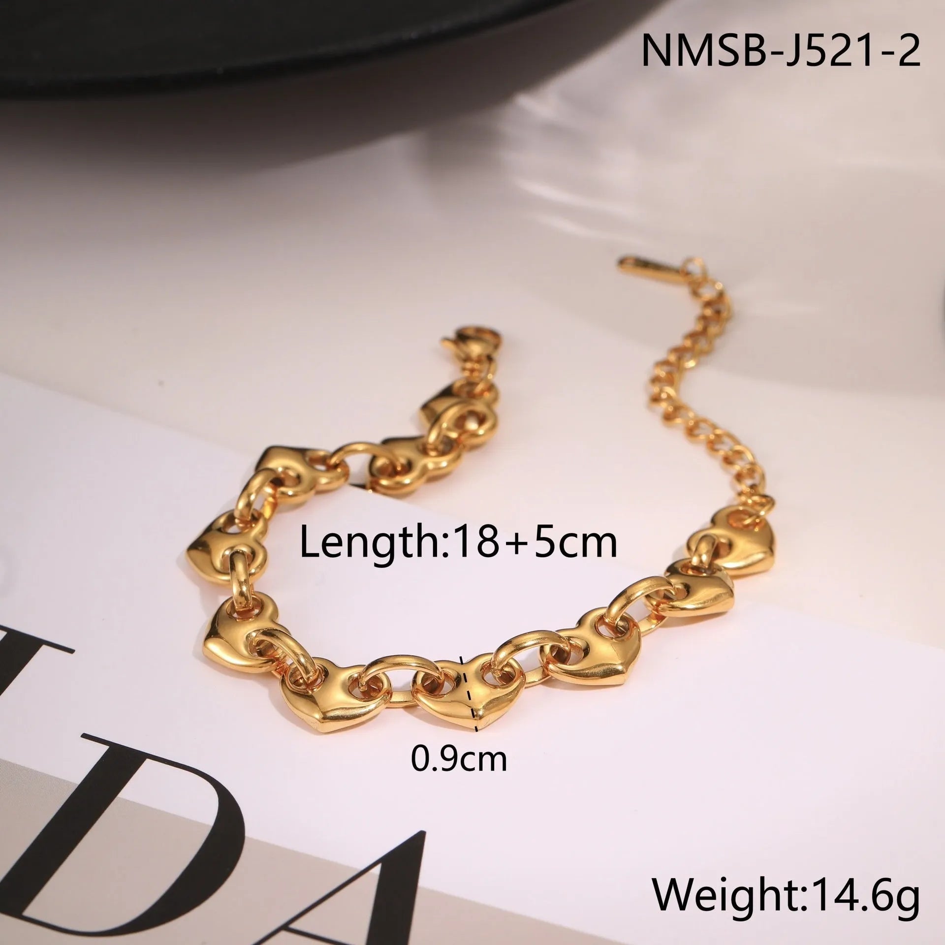 Hollowed-out heart geometry bracelet in stainless steel with gold electroplated finish on a wrist.