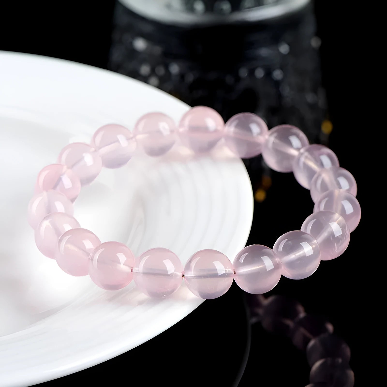 Close-up of a polished natural starlight crystal round bead bracelet in pink, showing single circle design.