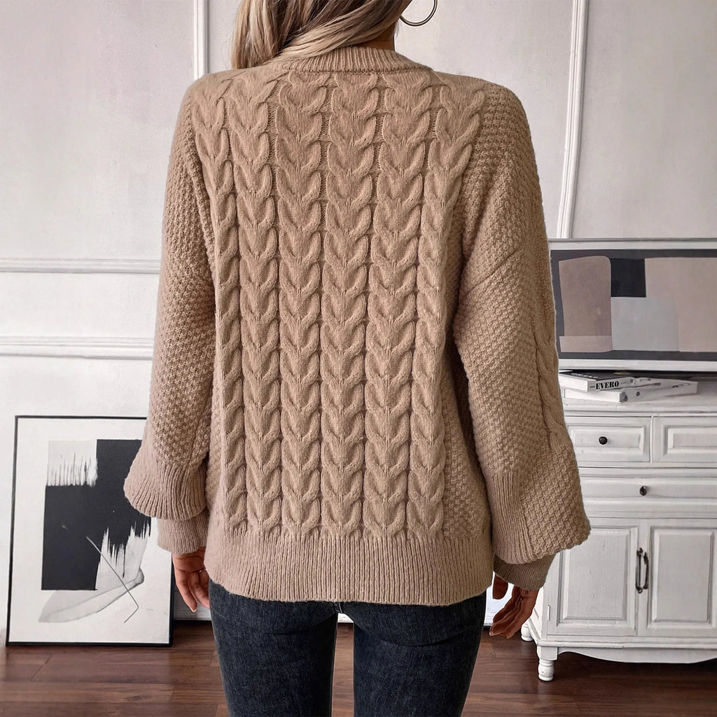 Woman wearing a loose beige casual sweater with a twisted texture detail on the front.