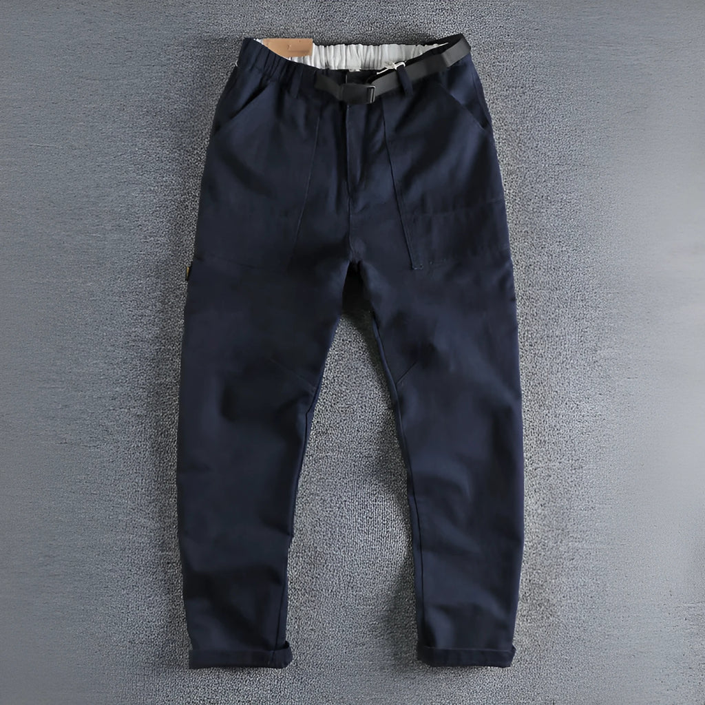 Men's khaki cotton work trousers with N I buckle belt and three-dimensional cut on a hanger.