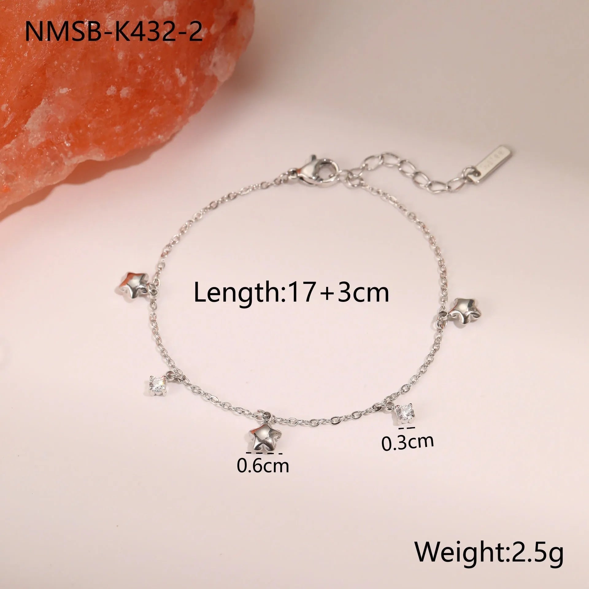 Gold plated stainless steel bracelet with a detailed zircon star pendant on a woman's wrist.
