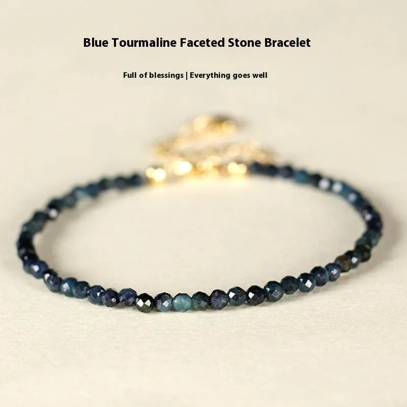3mm blue tourmaline cut bead bracelet with spacer beads on a wrist