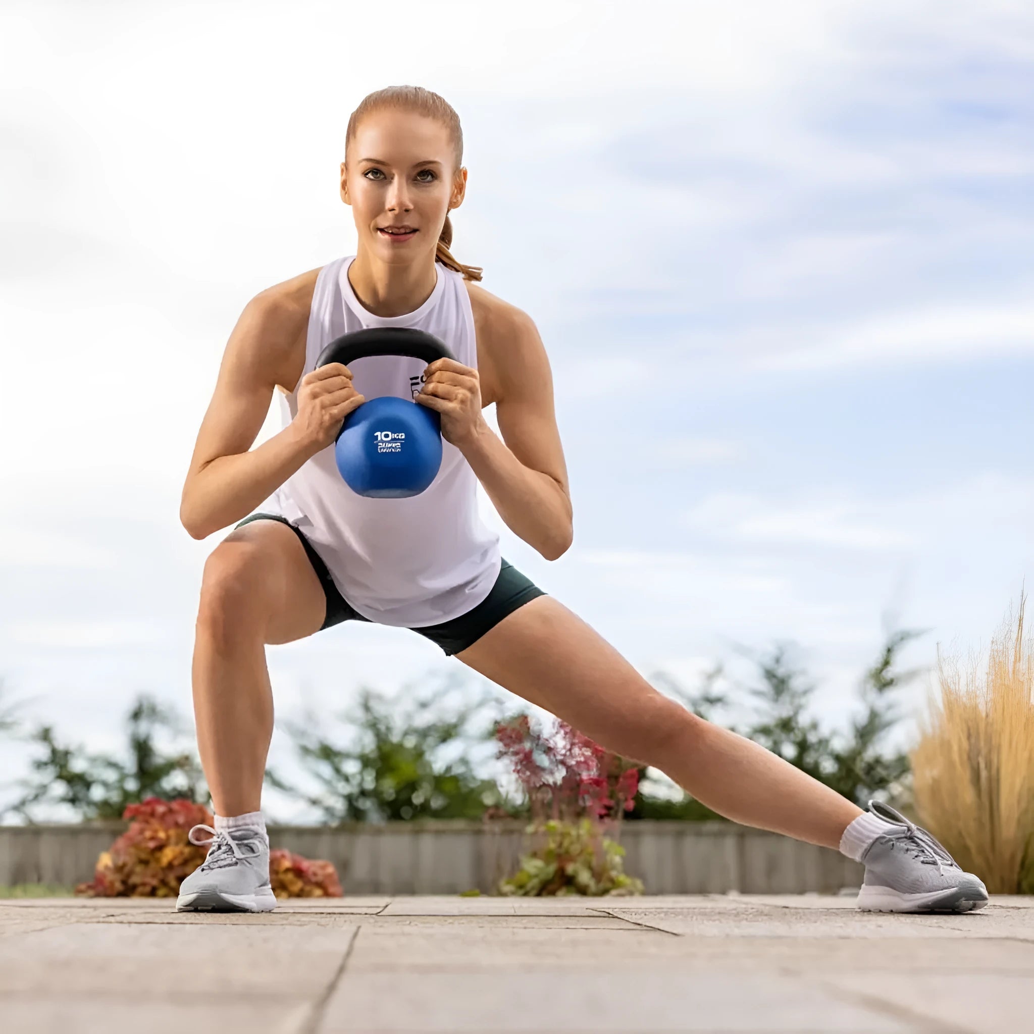 A blue cast iron dumbbell shaped like a teapot, showing its 10 kg weight and solid construction.