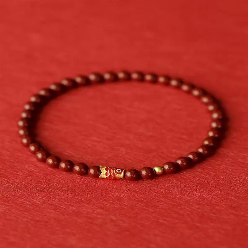 Natural cinnabar koi bracelet with golden ball charm in traditional Chinese style design