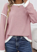 A beige loose knit top with a four leaf clover print and contrasting trim on the sleeves and hem.