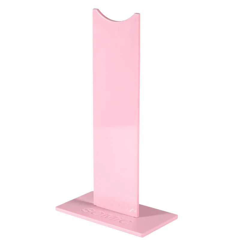 Pink and black detachable headset bracket with a non-slip silicone base on a desk