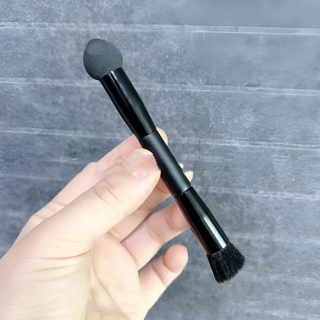 Black concealer brush with a tapered fibre head and wooden handle for makeup application.