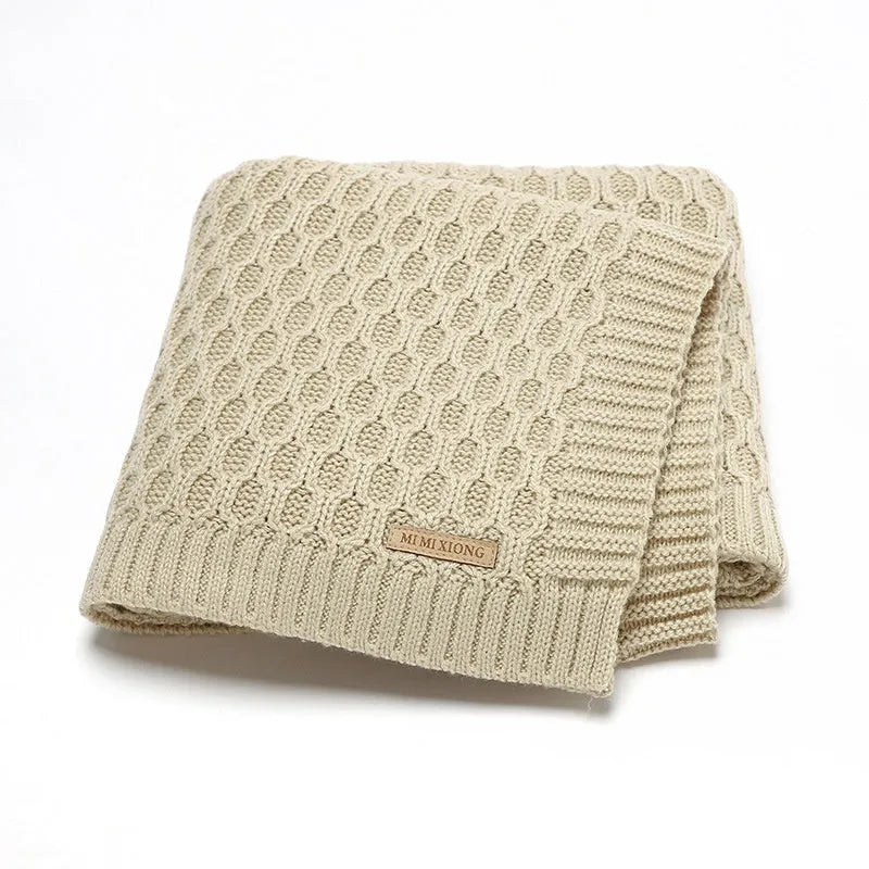 Solid colour acrylic infant hug blanket with textured lines, shown in beige khaki colour.