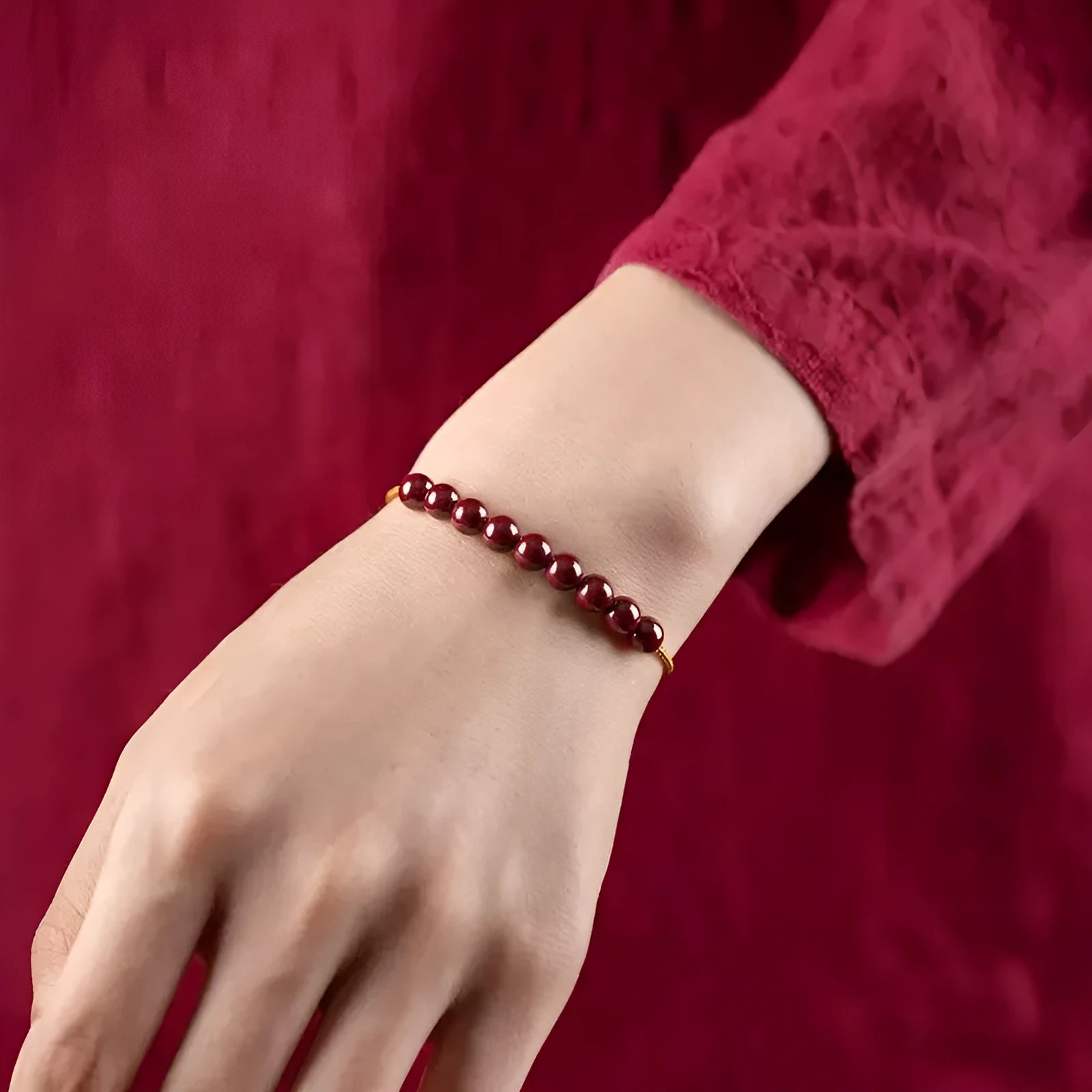 Close-up of a hand-woven geometric bracelet made from cinnabar and Hetian jade stones.