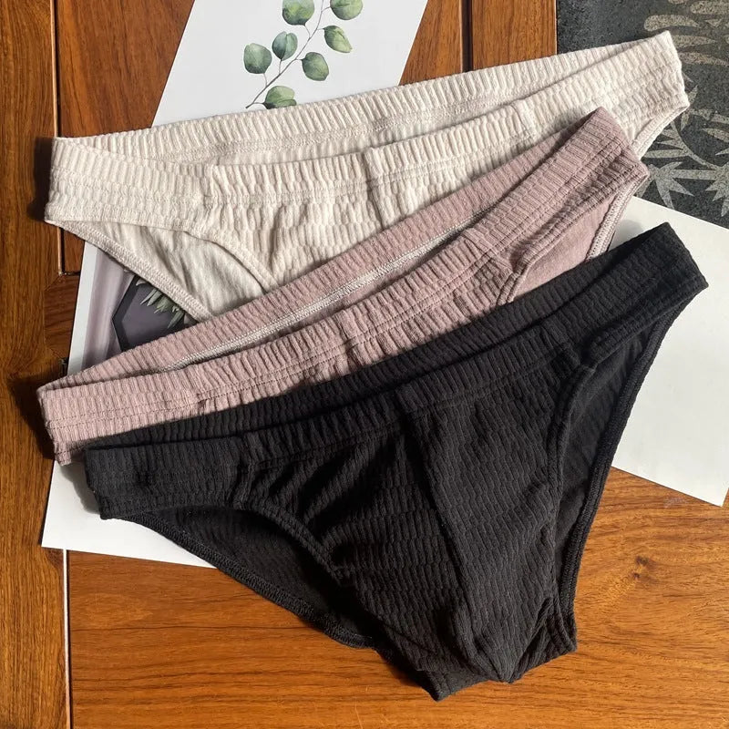 Men's solid colour cotton triangle briefs in mid-waist style, shown in apricot and black colour options.
