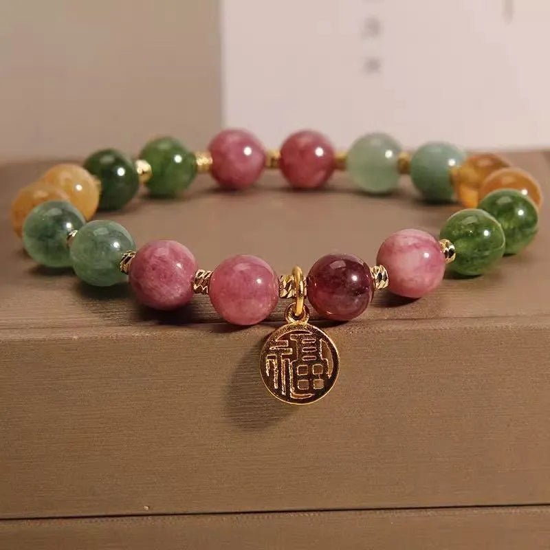 Natural colour tourmaline bracelet with floral beads and geometric design on wrist