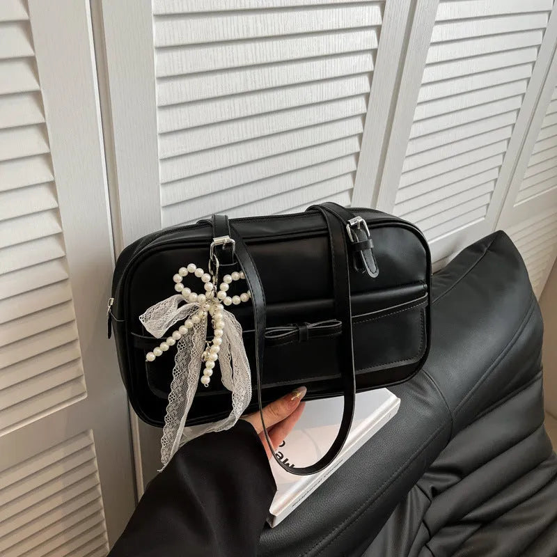 Single-shoulder flap bag in horizontal square shape with bow decoration and internal phone compartment