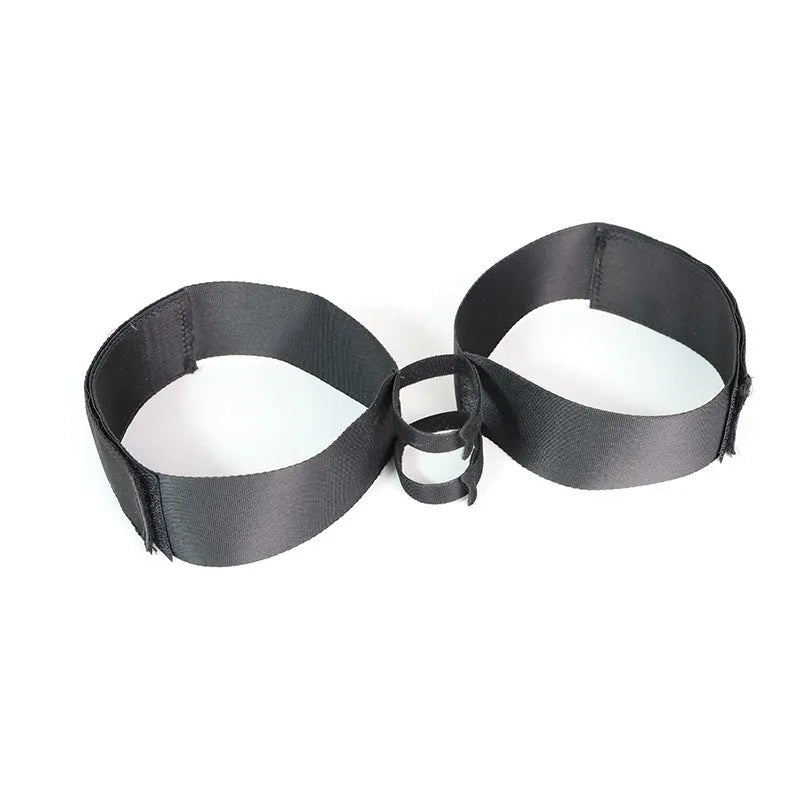 Black knitted belt strap sex toy laid flat, showing adjustable fastening mechanism.