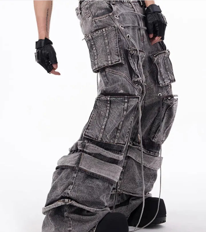 Grey distressed denim overalls for men with rope stitching on the legs and a mop pant cut.