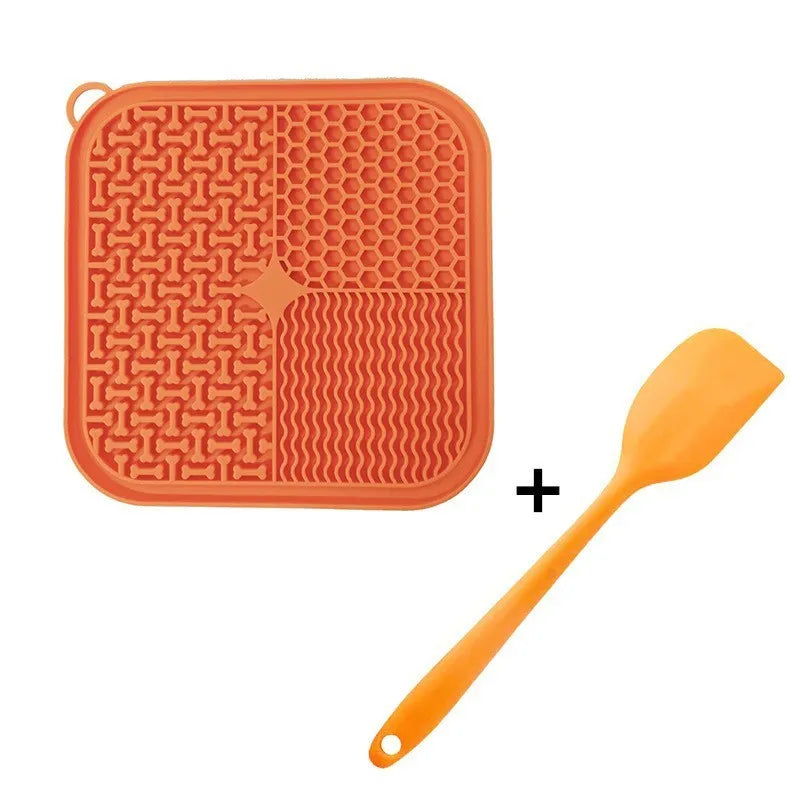 Orange, grey, blue, and green silicone dog licking mat with suction cups on a smooth surface.