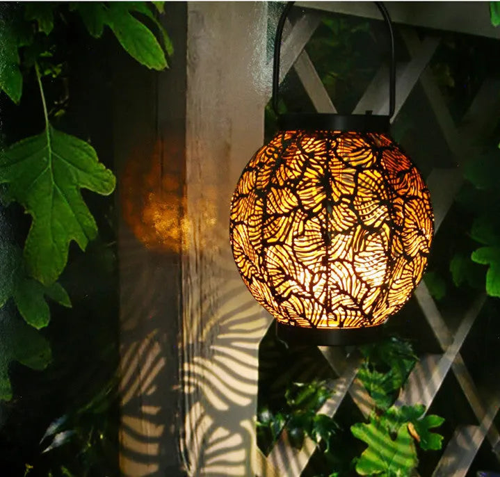 Solar courtyard lamp with hollow iron decorative design emitting warm white LED light