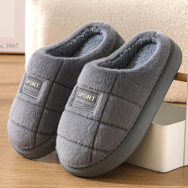 Men's grey plaid rabbit hair slippers with a thick sole, shown on a wooden floor.